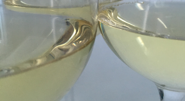 Närbild på glas med vitt vin 